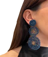 Aros colgantes largos con forma de círculos tramados con cuentas de cristal color turquesa.