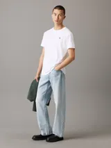 Remera blanca de algodón con cuello redondo, corte regular, mangas cortas y logo de Calvin Klein bordado en el pecho.