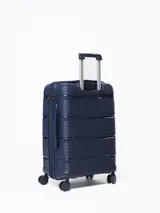 Valija rígida de viaje color azul marino con diseño de líneas horizontales en relieve. Tiene manija retráctil de aluminio, cuatro ruedas con giro de 360°, cierre con combinación y manija lateral. Interior forrado con divisor y bolsillo de malla.