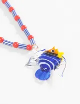 Collar con cuentas de cerámica rojas y azules, con dije de pez tropical de vidrio soplado en tonos azules, amarillos y blancos.