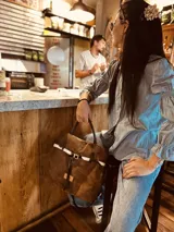 Bolso marrón de cuero gamuzado con correa bandolera de cuero marrón y detalle de cuero con estampado animal print.