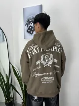 Buzo marrón con capucha y estampado en la espalda con texto y logo de león. Corte holgado.