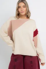 Buzo de punto color crema con bloques geométricos en tonos rosa y rojo.