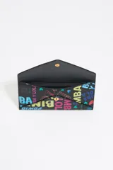 Monedero tipo sobre de cuero sintético negro con estampado de letras y logos de la marca en colores.