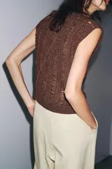 Top tejido de punto color marrón con cuello redondo y sisa.