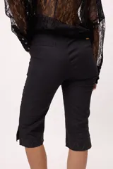 Pantalón capri negro con terminación en picos y costuras en color ladrillo.