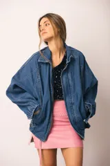 Campera de denim azul de corte oversize, con cuello, cierre frontal, bolsillos laterales amplios y ajuste en puños y bajo.