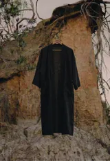 Kimono largo midi de color negro, con mangas amplias y calce relajado y fluido. Presenta bolsillos frontales.