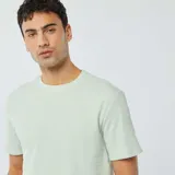 Remera de manga corta color verde claro, con cuello redondo y textura de punto jacquard.
