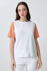 Remera de manga corta con diseño color block en crudo, blanco y negro.