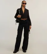 Blazer negro cropped de corte slim, con escote en V, solapas y un único botón frontal.