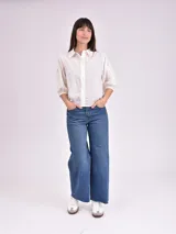 Camisa blanca de mangas 3/4 con detalles de calado en las mangas.
