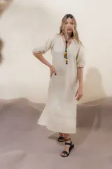 Vestido largo rojo con escote en V, mangas abullonadas con elástico en el puño y detalle de pespunte en contraste. Presenta un canesú con efecto punto smock y bolsillos laterales.