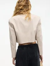 Blazer cropped marrón oscuro con solapa en la parte delantera y camisa desmontable mediante botones. Confeccionado en 97% algodón y 3% elastano.