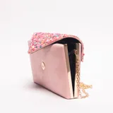 Sobre o clutch rectangular color rosa pálido, con solapa triangular decorada con lentejuelas multicolores. Incluye una cadena fina dorada para usar como bandolera.