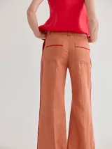 Pantalón de lino azul con corte palazzo y vivos a contratono color beige en los laterales.