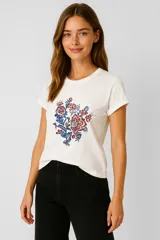 Remera blanca de algodón con estampado floral en el centro.