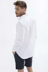 Camisa rosa de manga larga con cuello clásico y cierre frontal con botones. Corte recto.