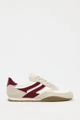Zapatillas deportivas con combinación de colores blanco, beige y bordó. Suela en contraste color caramelo. Cierre mediante cordones.