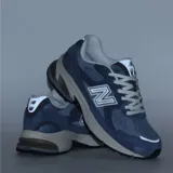 Championes New Balance modelo U2010WNV, color azul, con paneles de malla y gamuza, logo 'N' en gris y blanco, y detalles en gris claro y blanco en la suela.