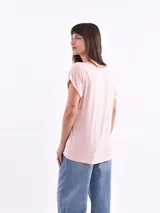 Remera de corte amplio color rosado con escote en V y mangas cortas.