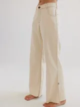 Pantalón jean color crudo, de corte recto y tiro alto, con costuras a contratono y terminación desflecada en el ruedo.