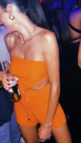 Top bandeau dorado con textura brillante y corte asimétrico en el ruedo.