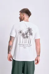 Remera blanca de manga corta con estampa de palmeras y texto "Chilling in the Sun" en la espalda.