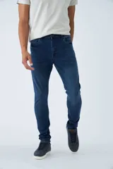 Jean skinny de tiro medio, color azul oscuro, con logo bordado y pasacinto.