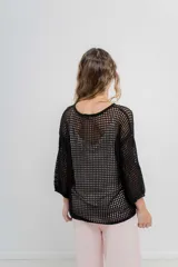 Buzo negro de punto abierto con diseño calado, mangas largas abullonadas y cuello redondo.