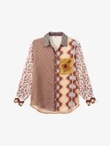 Camisa de manga larga con botones y cuello, con estampado colorido en tonos cálidos.