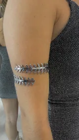 Brazalete plateado con diseño de hojas.
