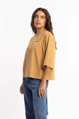 Remera blanca de corte cuadrado con cuello subido y mangas 3/4 amplias.