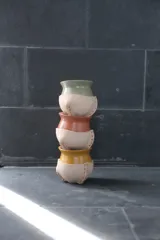 Mate de cerámica color crudo con detalle en cuero mostaza, de diseño moderno y pequeño.