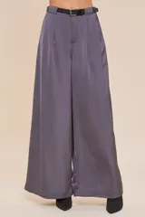 Pantalón palazzo de pierna ancha color gris, con acabado satinado y cinturón negro.