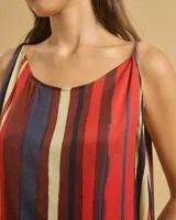 Top fluido con tirantes finos trenzados y escote barco, con estampado de rayas verticales rojas, azules y amarillas.