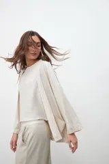 Kimono color crudo con laminado plateado, mangas 3/4 amplias y bolsillos laterales.