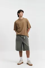 Remera de manga corta color marrón claro, corte oversize y cuello redondo.