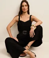 Mono de mujer color rojo oscuro (bordó), de corte recto y pierna ancha, con escote corazón y tirantes anchos con elástico. Presenta pliegues frontales que caen rectos hasta el ruedo.