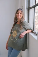 Remera verde militar de lino con estampado de una flor dorada.