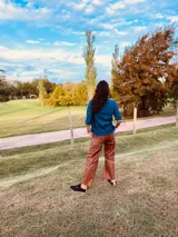 Pantalón cargo de cuero color suela, con tiro medio, corte suelto y pespuntes blancos en contraste.