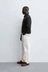 Jersey de punto perlado negro, de corte relaxed fit, con cuello perkins y cierre frontal de cremallera.