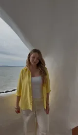 Camisa amarilla de crepé, de corte clásico, manga larga con puños abotonados y cuello camisero.