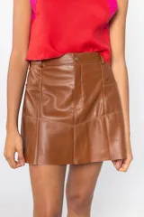 Minifalda color camel de cuero sintético, con paneles pespunteados y bolsillos delanteros.