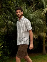 Camisa de manga corta a rayas verticales color natural y azul, con cuello clásico y cierre frontal con botones.