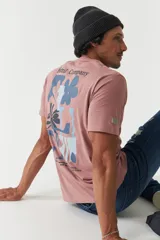 Remera blanca de manga corta con cuello redondo y estampado con flores y texto en tonos marrones.