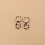 Aros tipo argolla de plata 925 con cierre de bisagra, de los cuales cuelga un dije circular engastado con circonias brillantes.
