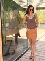 Top negro de cuero con escote en V y apliques de caracoles cosidos a mano en el escote.