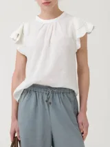 Blusa blanca de algodón orgánico y ramie, con mangas cortas con detalle de crochet y cuello redondo.