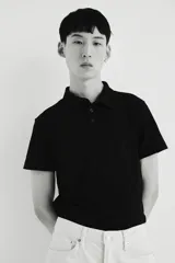 Remera polo negra de manga corta en piqué liviano de mezcla de algodón con cuello y tapeta de botones. Corte ajustado que realza el contorno del cuerpo creando una silueta entallada. Confeccionada con tejido funcional COOLMAX®, una fibra exclusiva de poliéster de secado rápido que elimina la humedad y regula la temperatura corporal proporcionando un ajuste cómodo y suave.